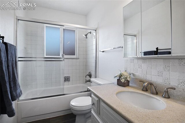 full bathroom with vanity, wood finished floors, toilet, backsplash, and shower / washtub combination