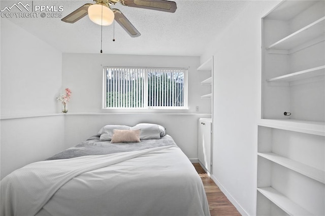 bedroom featuring a ceiling fan, a textured ceiling, and dark wood-style floors