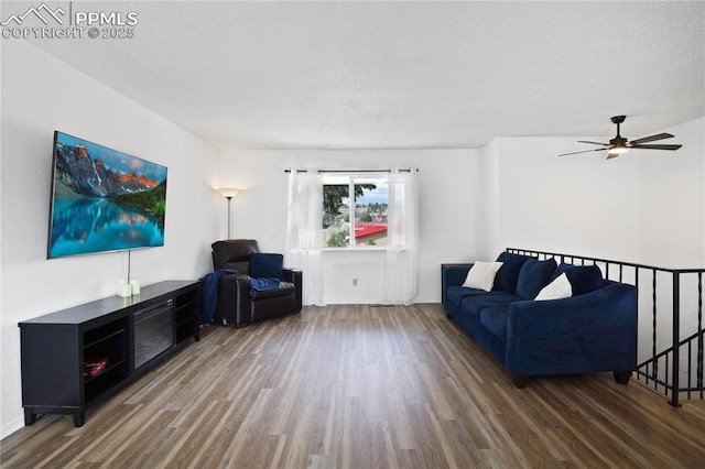 living area with a textured ceiling, ceiling fan, and wood finished floors