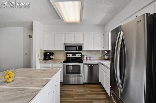 kitchen featuring light countertops, dark wood finished floors, white cabinetry, and stainless steel appliances