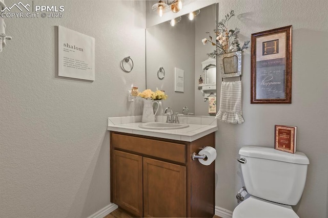 5409 Haes Haven Vw, Colorado Springs, CO 80908 - half bathroom featuring toilet, vanity, and a textured wall