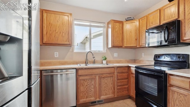 70 Audubon Dr, Colorado Springs, CO 80910 - kitchen featuring light countertops, a sink, black appliances, and visible vents