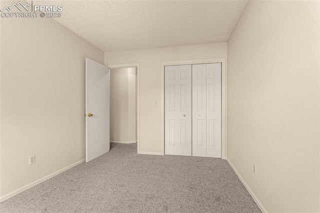 unfurnished bedroom with a closet, baseboards, carpet, and a textured ceiling