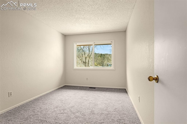 carpeted spare room with a textured wall, baseboards, and a textured ceiling
