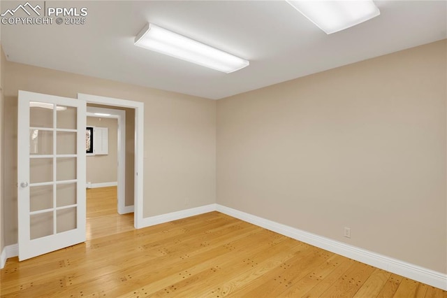 spare room with light wood-type flooring and baseboards