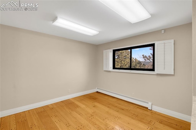 empty room featuring baseboards, a baseboard heating unit, and light wood finished floors