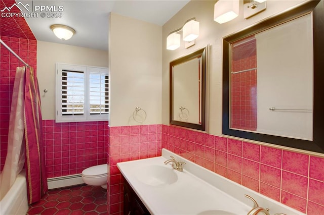 bathroom featuring a baseboard heating unit, tile walls, a sink, toilet, and tile patterned flooring