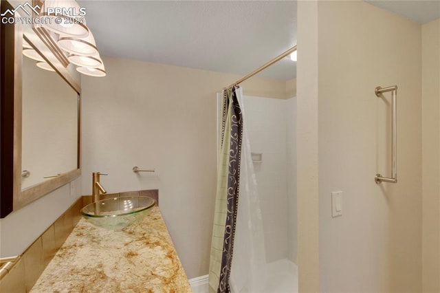 full bath featuring a shower with shower curtain and vanity