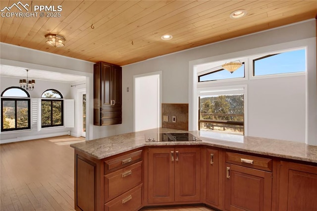 kitchen with wood ceiling, light stone countertops, and black electric cooktop