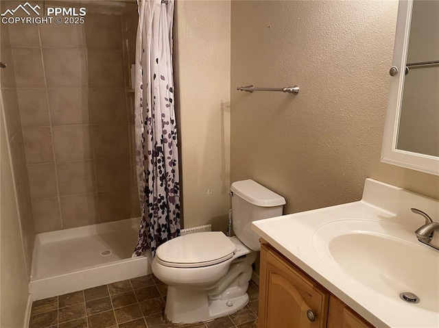 bathroom featuring a textured wall, toilet, a stall shower, and vanity