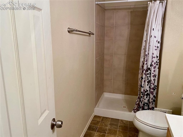 bathroom with a stall shower, baseboards, toilet, and vanity