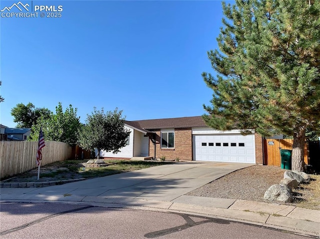 view of front facade featuring driveway, an attached garage, fence, and brick siding