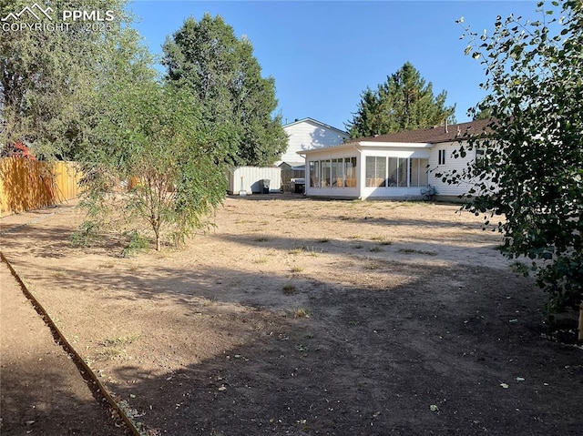 view of yard featuring a sunroom and fence