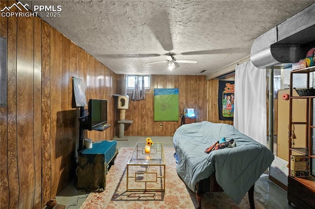 bedroom with a textured ceiling and wood walls
