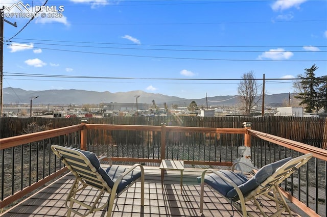 deck with a mountain view and a fenced backyard