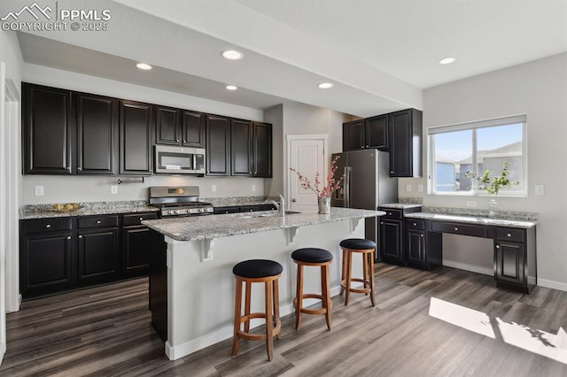 1632 Derbyshire St, Colorado Springs, CO 80910 - kitchen featuring a breakfast bar area, dark wood-type flooring, stainless steel appliances, dark cabinets, and recessed lighting