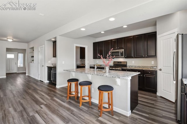 1632 Derbyshire St, Colorado Springs, CO 80910 - kitchen featuring a breakfast bar, appliances with stainless steel finishes, a center island with sink, dark wood-style floors, and recessed lighting