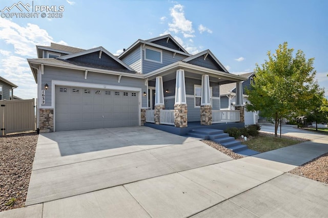 1632 Derbyshire St, Colorado Springs, CO 80910 - craftsman inspired home featuring stone siding, fence, an attached garage, concrete driveway, and covered porch