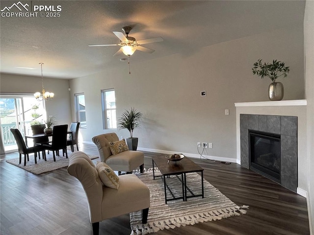 1632 Derbyshire St, Colorado Springs, CO 80910 - living area with dark wood-type flooring, baseboards, ceiling fan with notable chandelier, and a tile fireplace