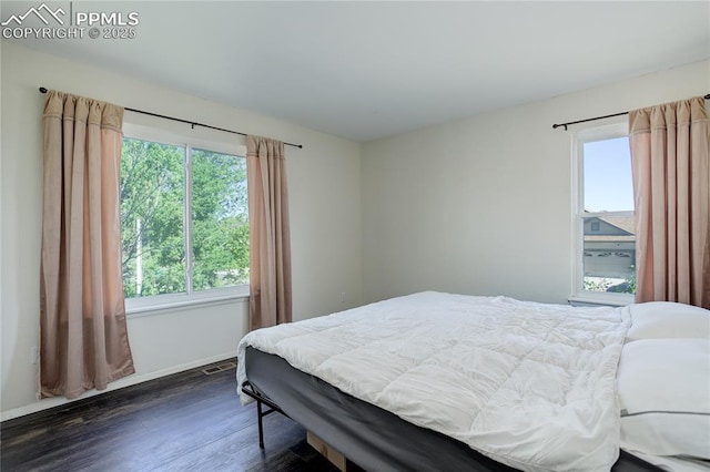 4730 Jenson Ln, Colorado Springs, CO 80922 - bedroom with multiple windows, dark wood-type flooring, and baseboards