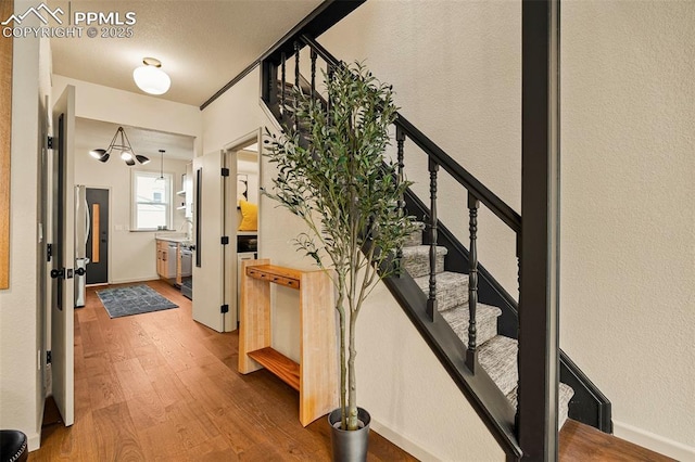 entrance foyer featuring baseboards, wood finished floors, and stairway