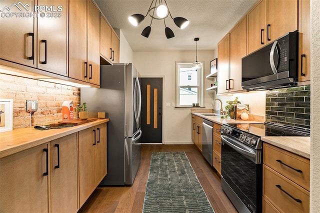 kitchen with a sink, decorative backsplash, stainless steel appliances, and dark wood-style flooring