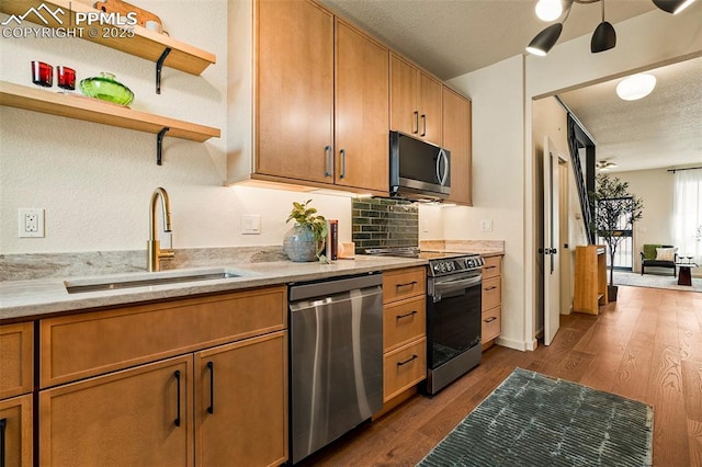 kitchen featuring open shelves, brown cabinets, a sink, stainless steel appliances, and dark wood-type flooring