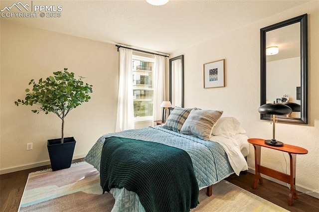 bedroom featuring baseboards and wood finished floors