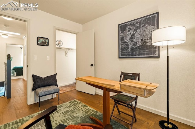 home office with baseboards and wood finished floors