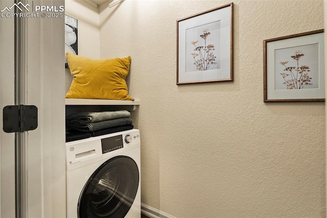laundry room with washer / dryer, a textured wall, and laundry area