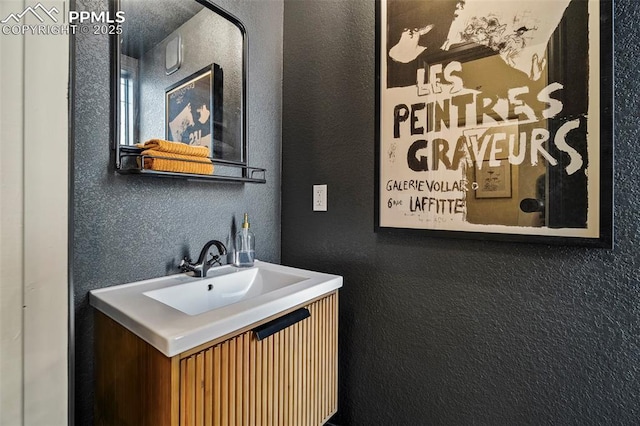 bathroom featuring vanity and a textured wall