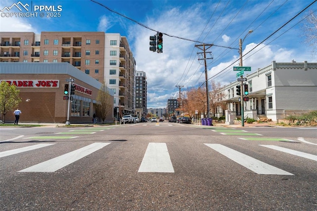 view of street featuring traffic lights, curbs, street lights, and sidewalks