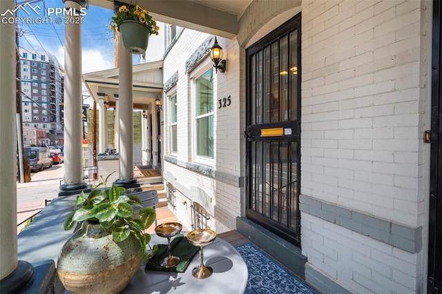 property entrance with brick siding and covered porch