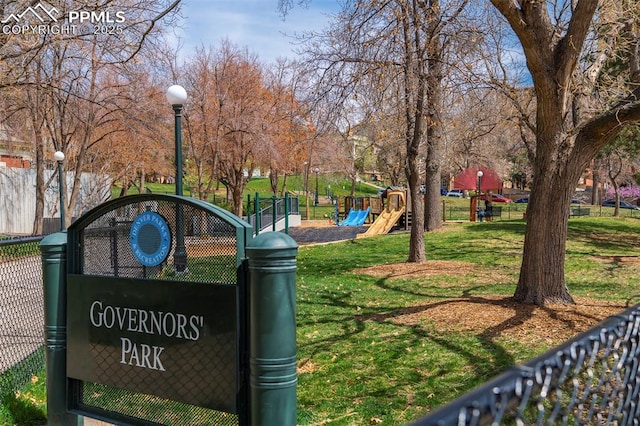 view of community with a lawn, fence, and playground community