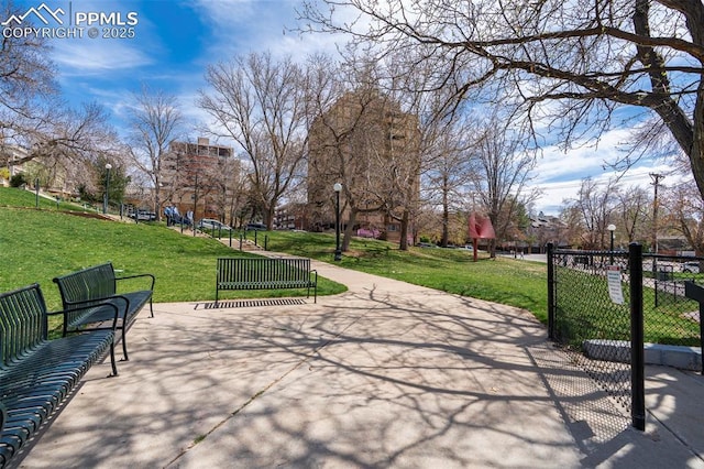 surrounding community with fence and a yard