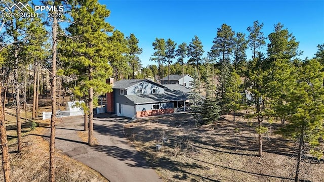 6770 Gun Club Trl, Colorado Springs, CO 80908 - exterior space featuring driveway, a chimney, and fence