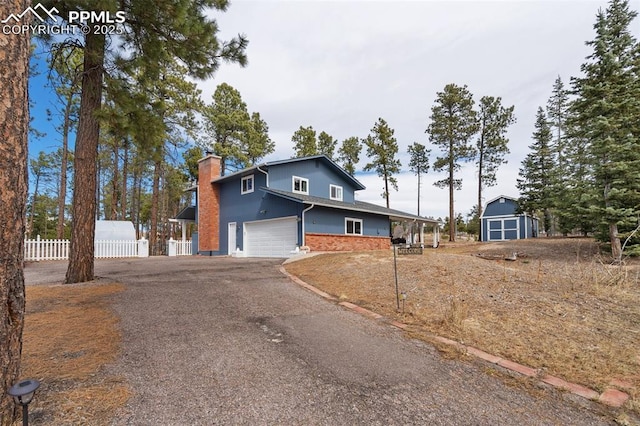6770 Gun Club Trl, Colorado Springs, CO 80908 - view of front of property featuring driveway, fence, an attached garage, brick siding, and a chimney