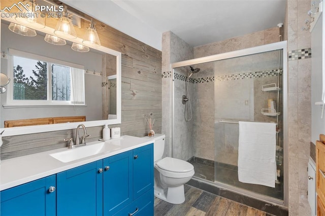 6770 Gun Club Trl, Colorado Springs, CO 80908 - full bathroom with toilet, wood finished floors, tile walls, a shower stall, and vanity
