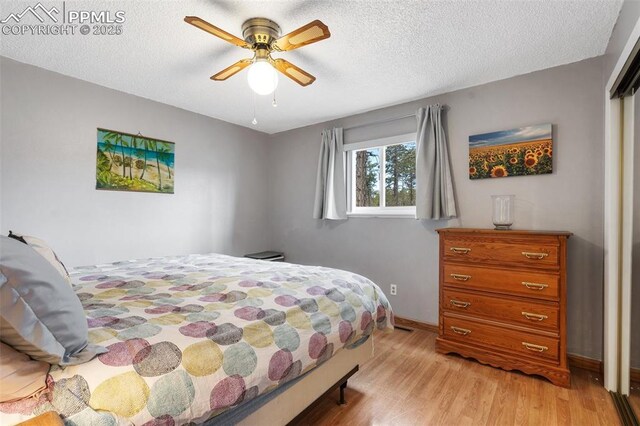 6770 Gun Club Trl, Colorado Springs, CO 80908 - bedroom featuring a textured ceiling, light wood-type flooring, baseboards, and a ceiling fan