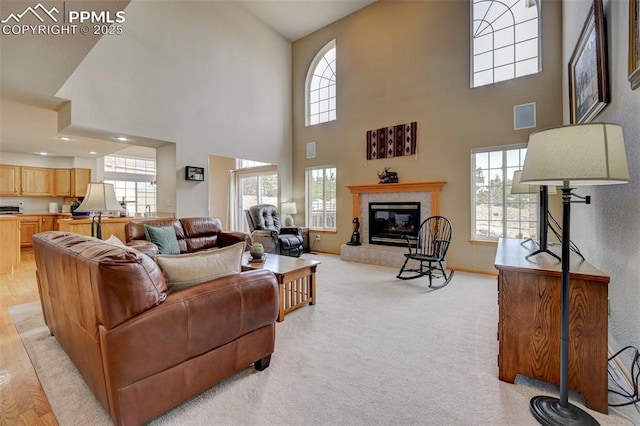 living area featuring a tiled fireplace, light carpet, baseboards, and visible vents