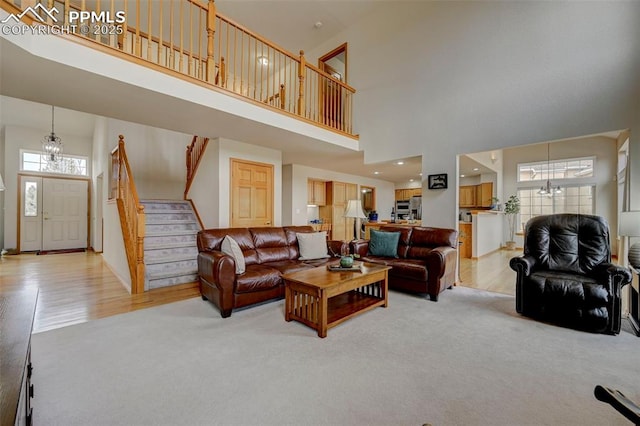 living room featuring stairs, a notable chandelier, and a high ceiling