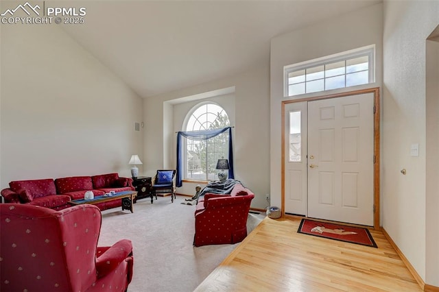 living room with high vaulted ceiling and wood finished floors