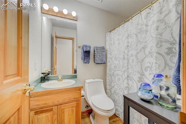 bathroom with wood finished floors, toilet, and vanity