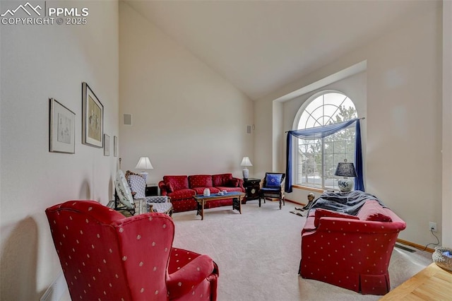living area featuring baseboards, high vaulted ceiling, and carpet flooring
