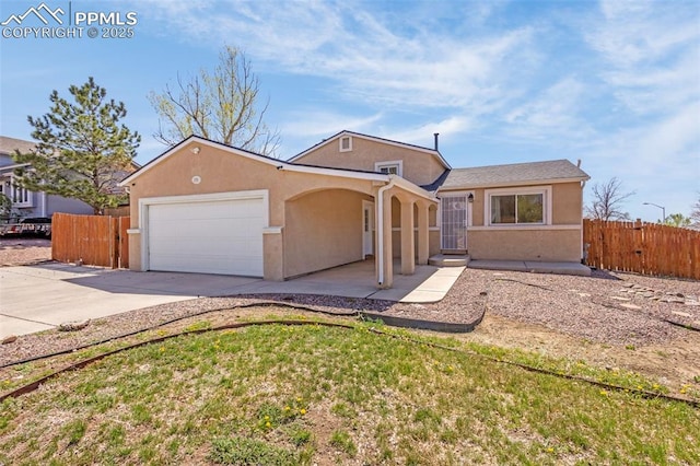 3781 Red Cedar Dr, Colorado Springs, CO 80906 - view of front of house featuring concrete driveway, an attached garage, fence, and stucco siding