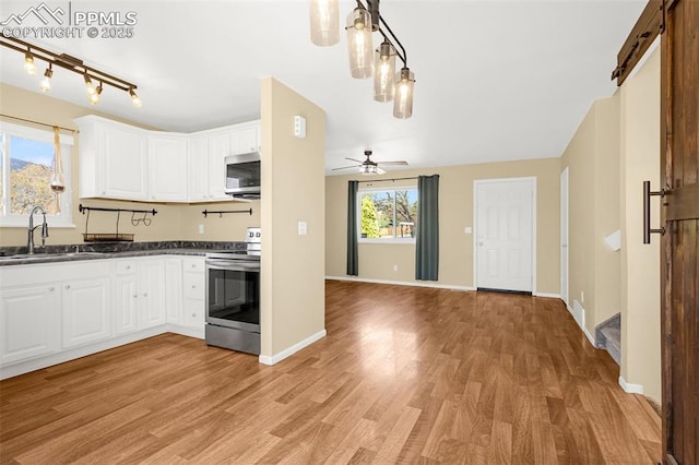 3781 Red Cedar Dr, Colorado Springs, CO 80906 - kitchen with light wood-type flooring, a sink, appliances with stainless steel finishes, and dark countertops