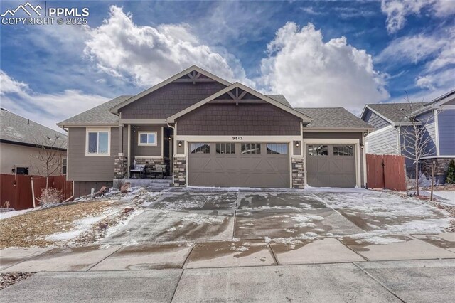 9812 Fairway Glen Dr, Peyton, CO 80831 - view of front of house with fence, stone siding, a garage, and concrete driveway