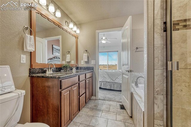 9812 Fairway Glen Dr, Peyton, CO 80831 - bathroom with toilet, a sink, a ceiling fan, ensuite bathroom, and a textured wall
