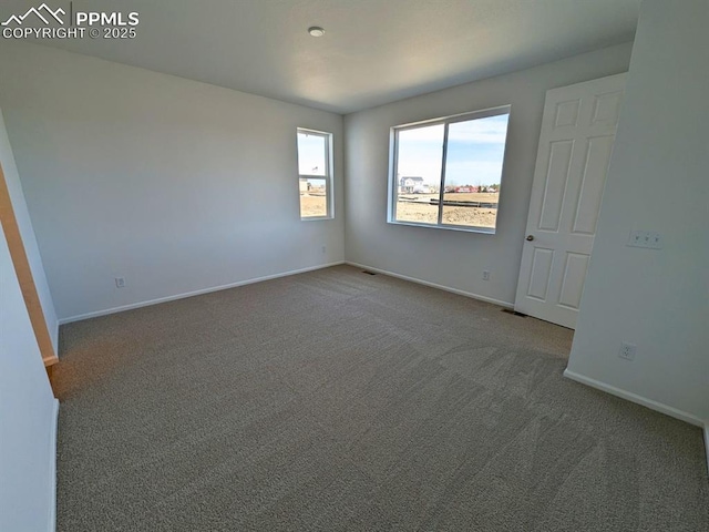 empty room with baseboards, carpet flooring, and visible vents