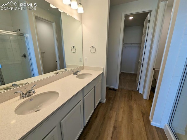 bathroom with a sink, toilet, a shower stall, and wood finished floors